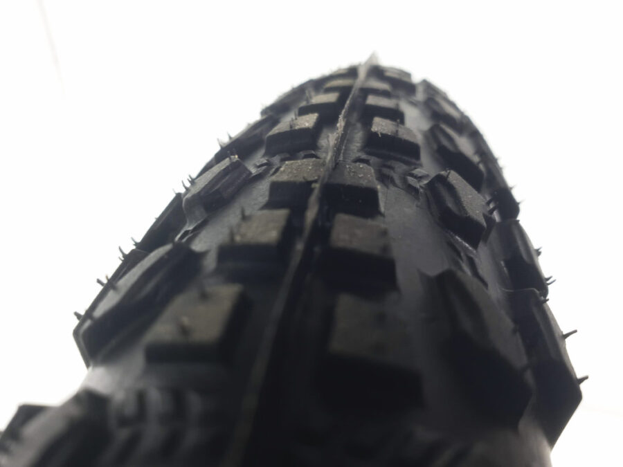 Anvelopă bicicletă cu crampoane mari, văzută de aproape.