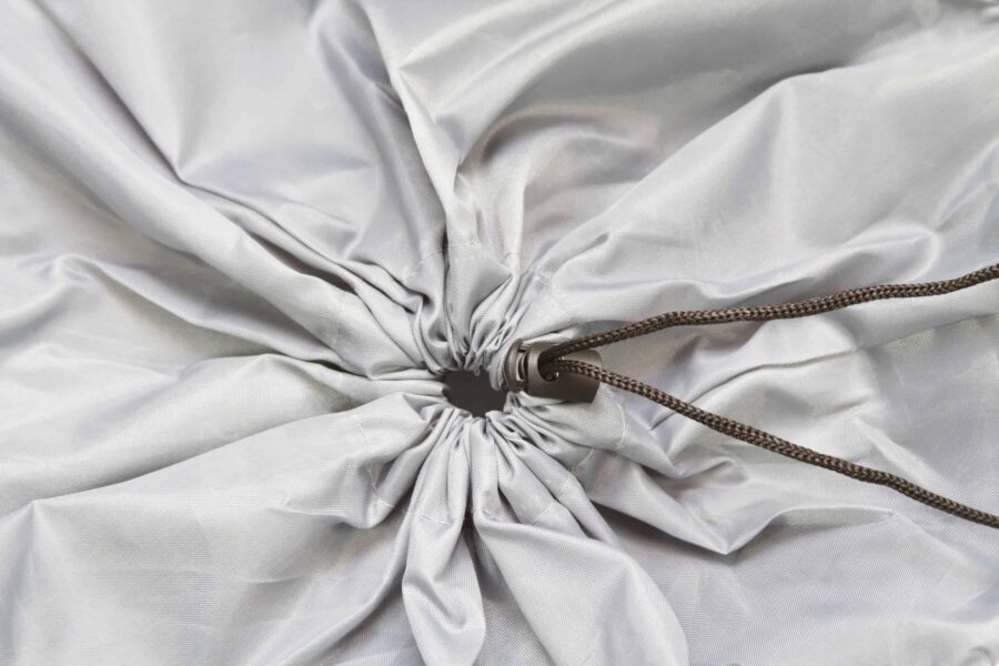 Detaliu cordon cu fermoar pe material textil gri