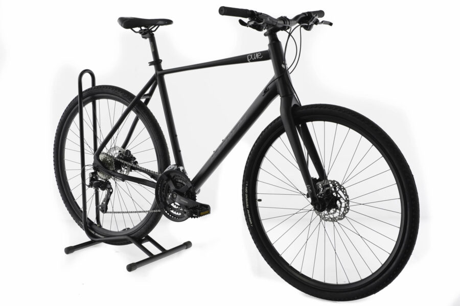 Bicicletă neagră de oraș, cu suport de parcare.