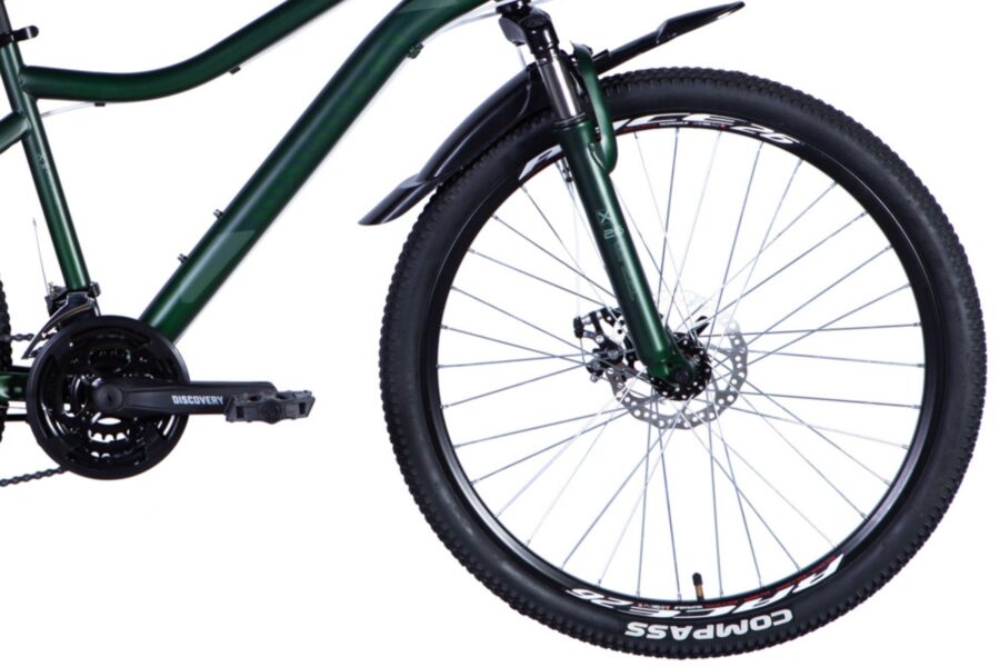 Bicicletă verde cu roți de teren și pedale.