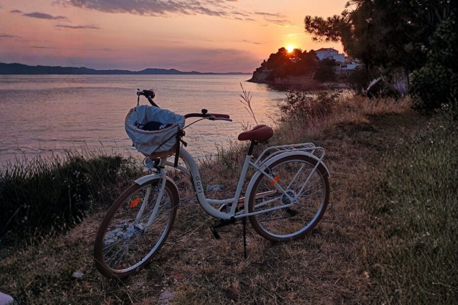 Bicicletă lângă mare la apus.