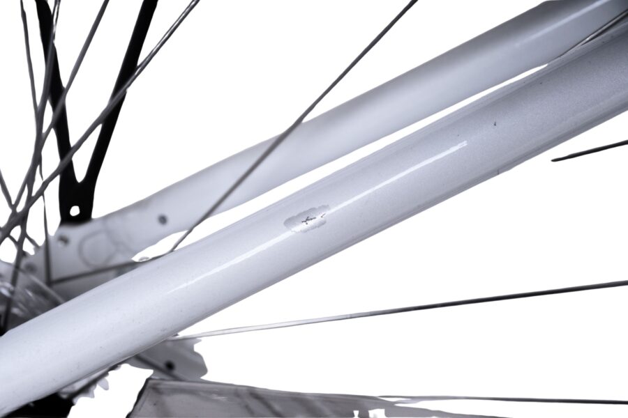 Zgârietură pe cadrul alb al bicicletei